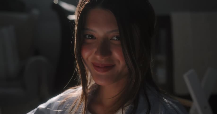 A woman is standing in a room and is smiling
