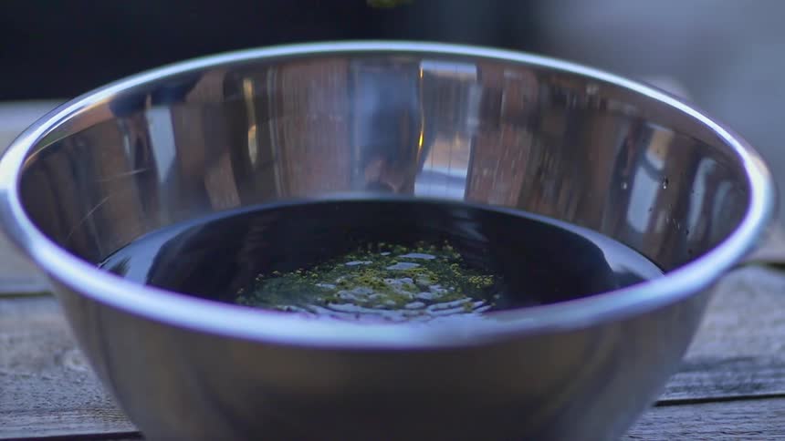 Powdered dye being added to a bowl of liquid dye