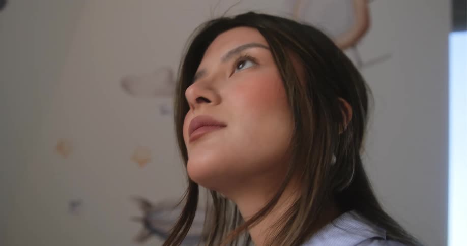 A woman is standing in a room and looking at the walls