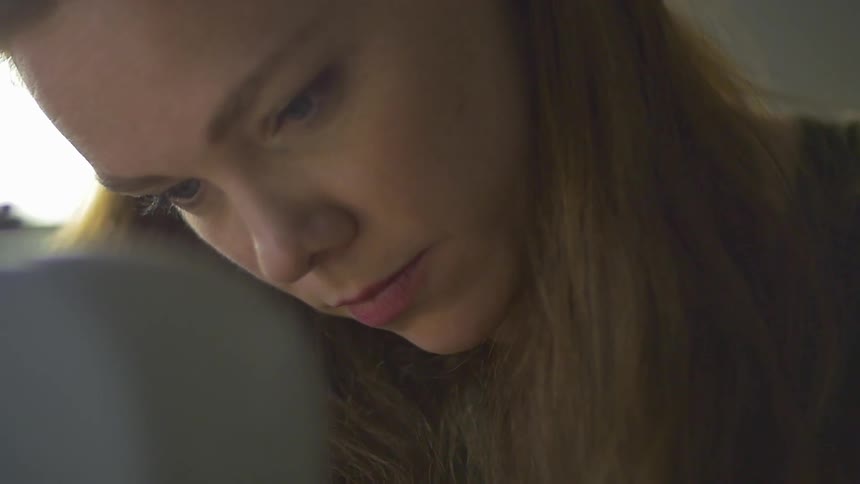 A woman looks down as she works on something