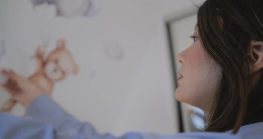 A woman is decorating walls in a room