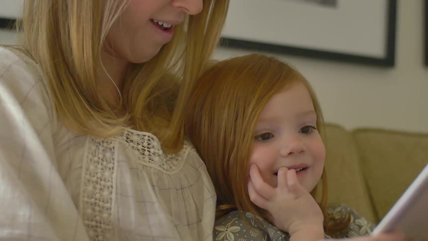 A woman reads to a little girl
