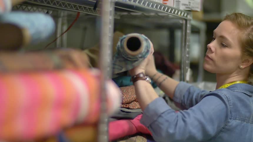 A woman checks fabric on a rack