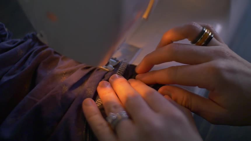 A zipper is being attached to clothing