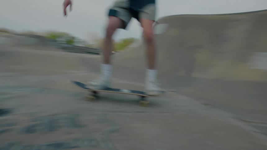 Teenager riding a skateboard on an empty skate park on a small town at evening