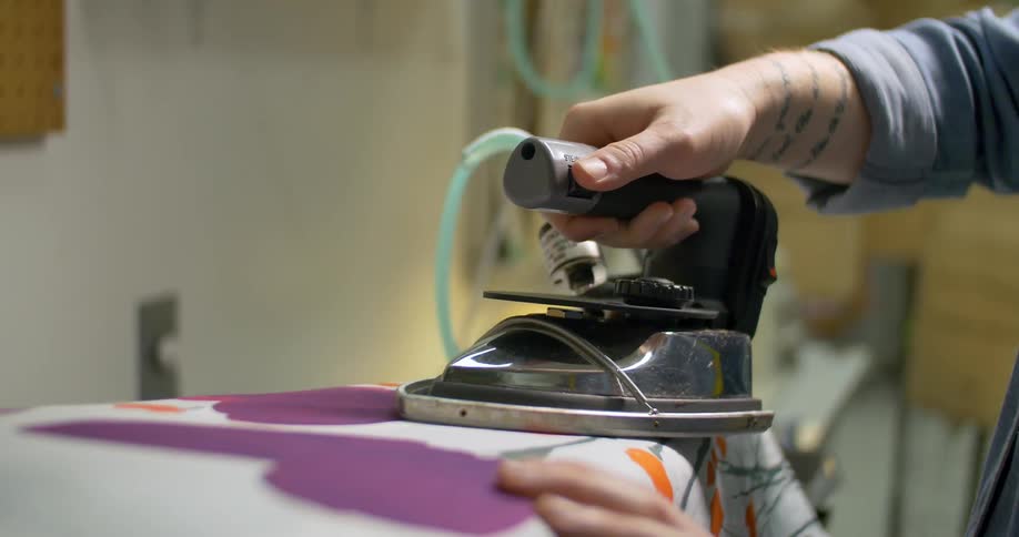 A person is ironing fabric on a board