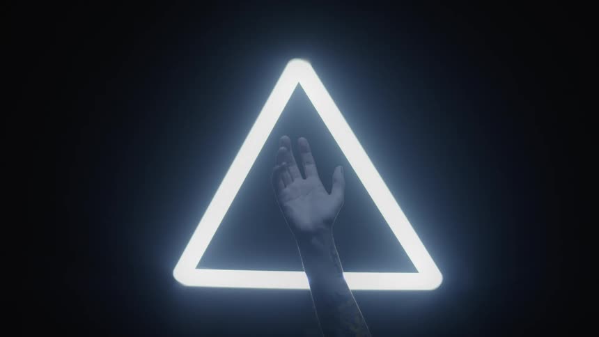 A glowing neon triangle in the darkness provides a backdrop for a lone hand that is raised