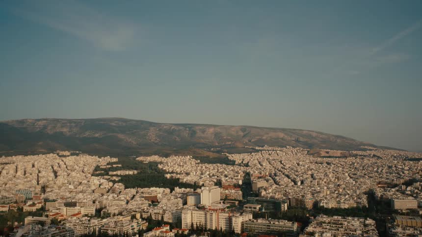 Aerial view of the buildings on a city close to a mountain at evening