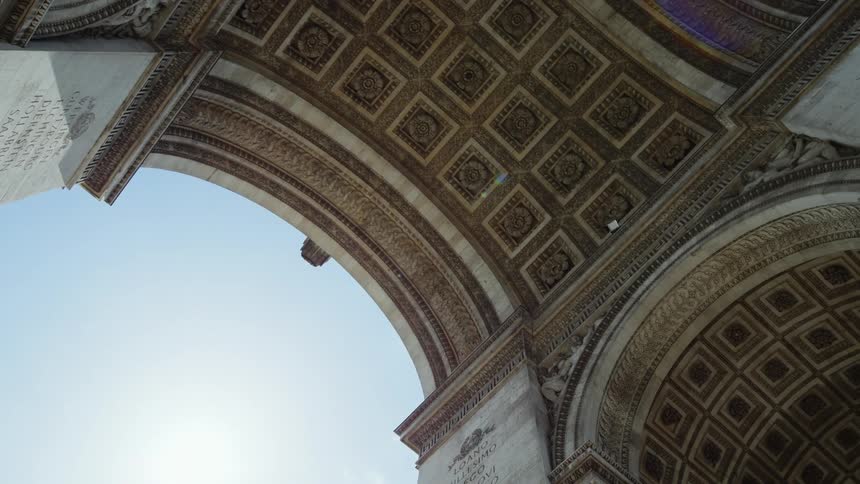 View looking up at the artwork and architecture inside an arch