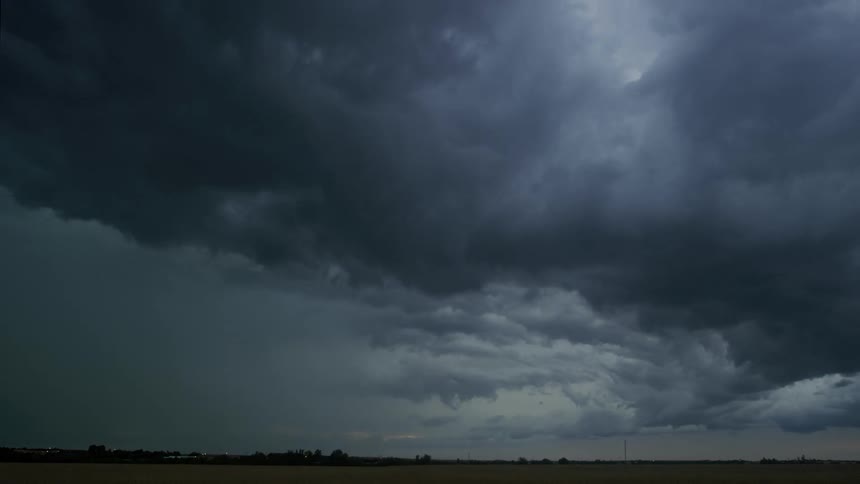 Time lapse of lightning flashing inside rolling dark storm clouds at evening