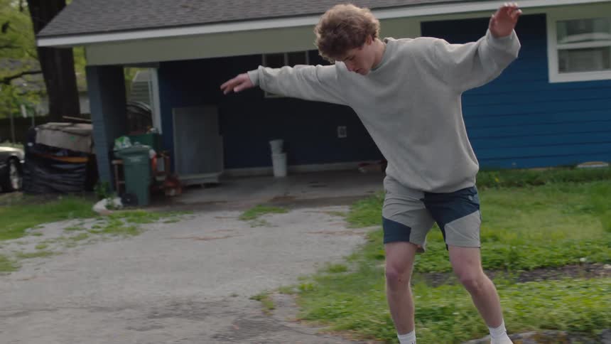 Teenager riding a skateboard on the neighborhood streets on a small town