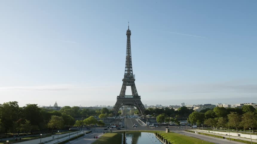 The eiffel tower stands tall overlooking paris under a clear blue sky