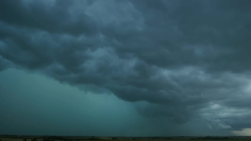 Time lapse of storm clouds rolling and churning in this teal colored dominant shot