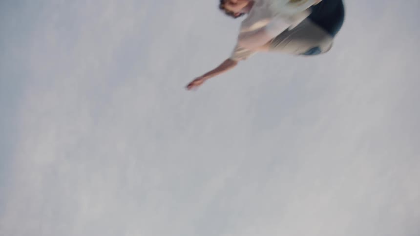 Teenage boy jumps over camera on skateboard