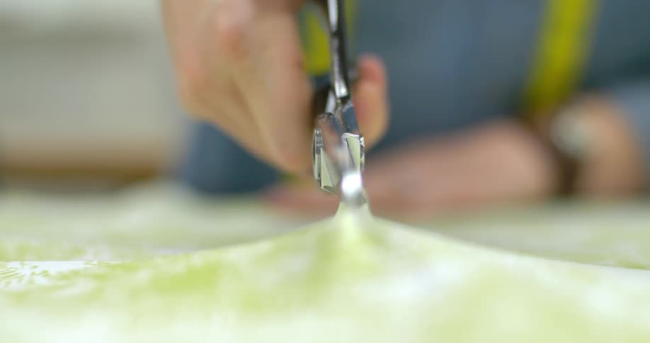 A person cuts fabric with scissors