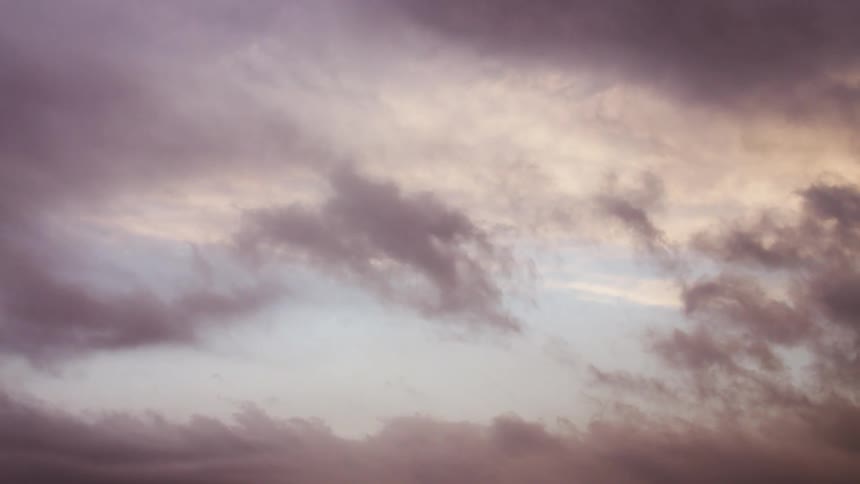 Dreamy time lapse of swirling and converging supercell storm clouds at sunset in the summer sky