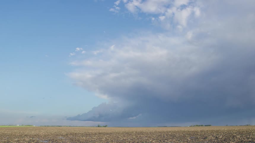 Time lapse of a huge super cell storm clearing out revealing a sunny sky and giant corn field