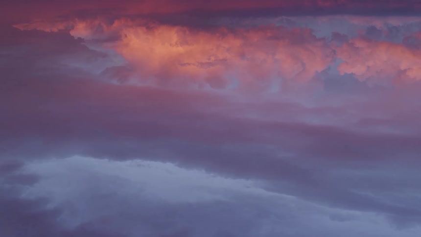 Abstract Time lapse of moving clouds changing pastel sunset colors on a blue sky