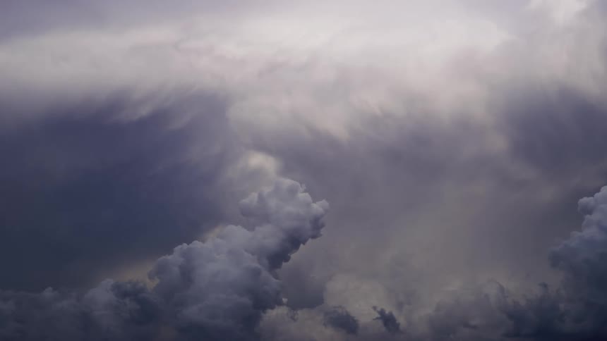 A time lapse shows huge cumulous clouds billowing into a beautiful yet mysterious night sky