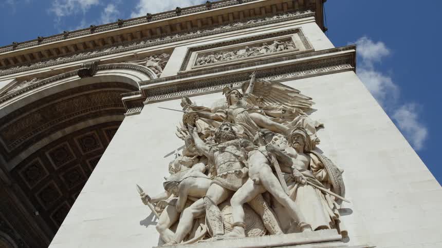 Sculptures on the face of the arch of triumph in paris under a blue sky