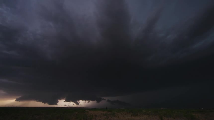 Wide time lapse of a massive supercell storm building and eventually darkening the entire frame