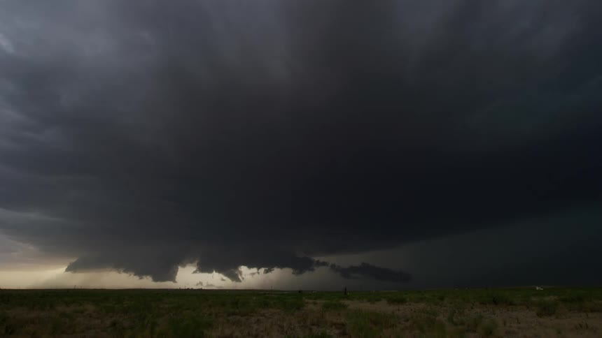 Time lapse of dark storm clouds are moving in rotation and closer to the ground as lightning strikes near Texas
