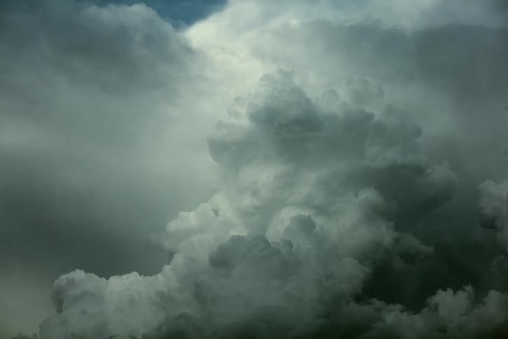Time lapse of massive cumulous nimbus clouds exploding upwards then crashing back to earth