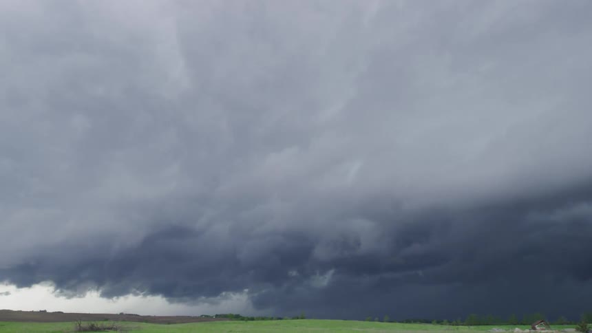 Time lapse of dark clouds float in the sky over field in Minnesota in the early summer