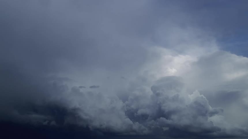 Time lapse of buiding and boiling cumulous nimbus storm clouds at sunset on a blue evening sky