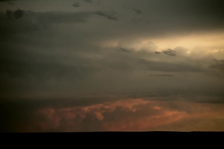 A severe thunderstorm fades and rolls into a beautiful evening sunset in Middle America
