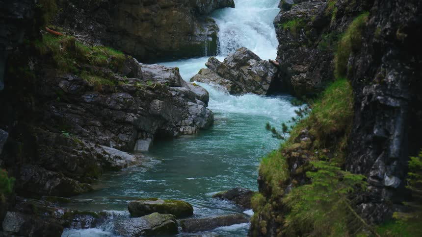 A narrow river runs over rocks in a canyon