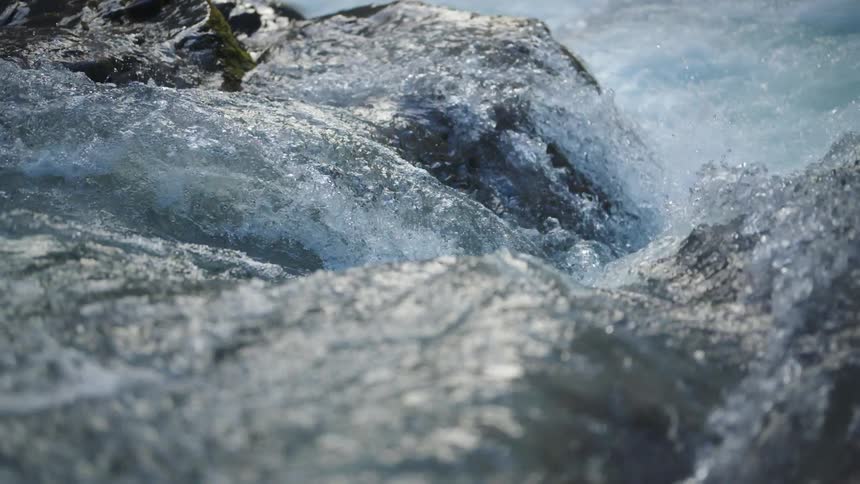 Water sparkles and splashes as it rolls over rocks and flows down the rapids