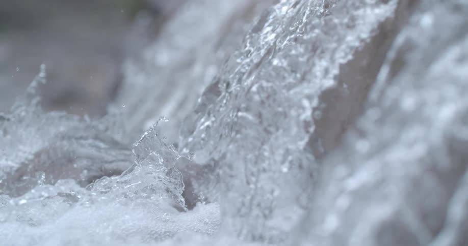 Water sparkles and splashes as it rolls over rocks
