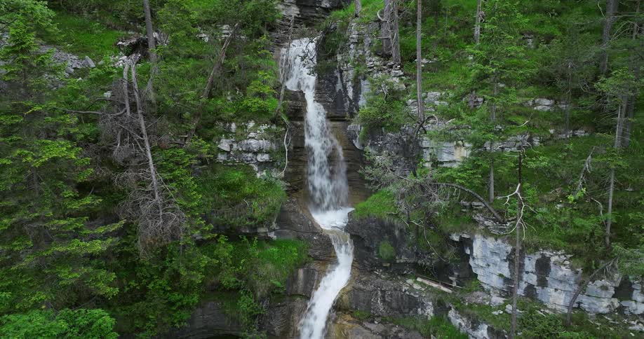 A waterfall rushes down the side of a cliff