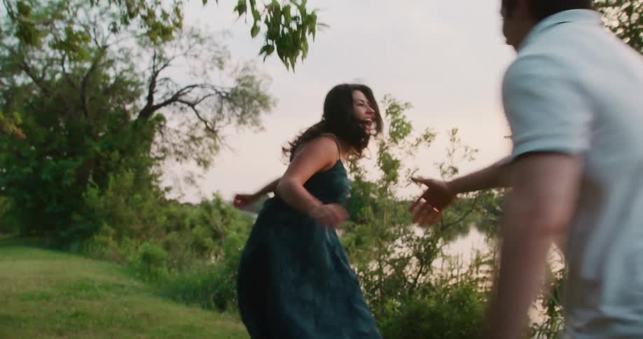 A couple is running outside and holding hands together