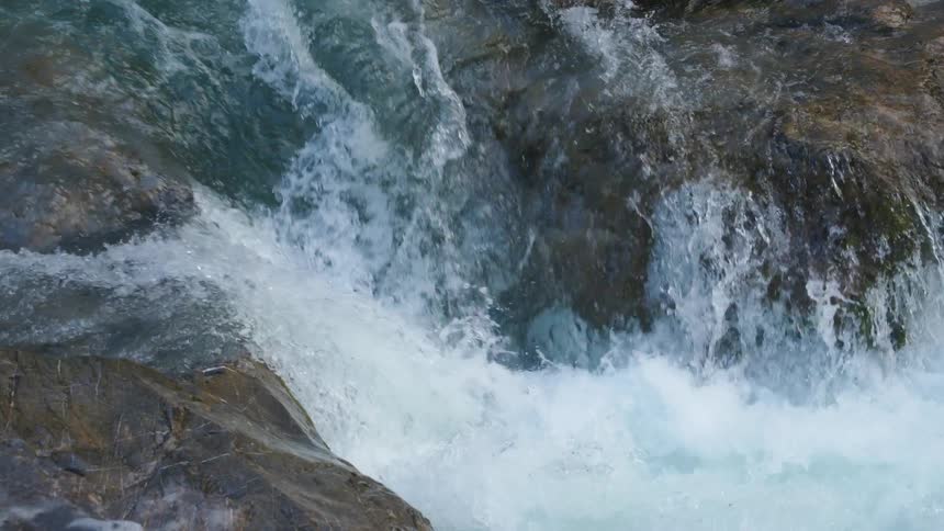 Waterfalls are flowing down the side of a mountain cliff