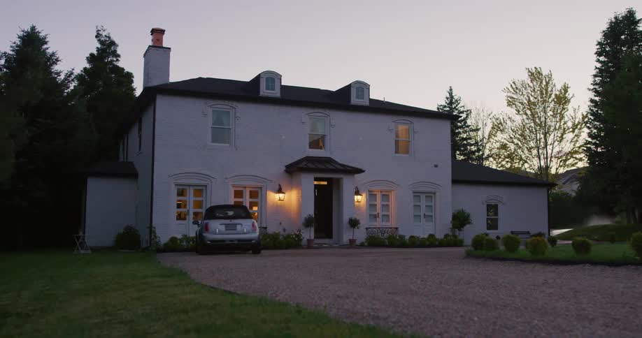 The lights come on inside the house in the yard
