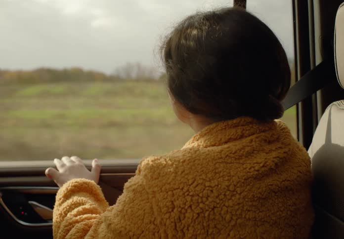 A child looks out the window of the moving car