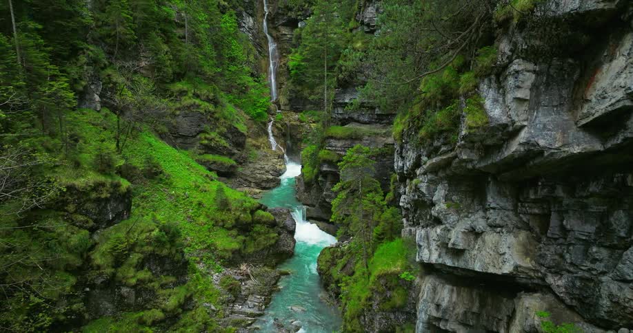 Aerial view of a river flowing near mountains is displayed