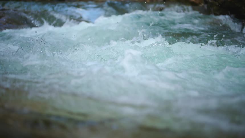 River water churns and foams as it flows through rapids