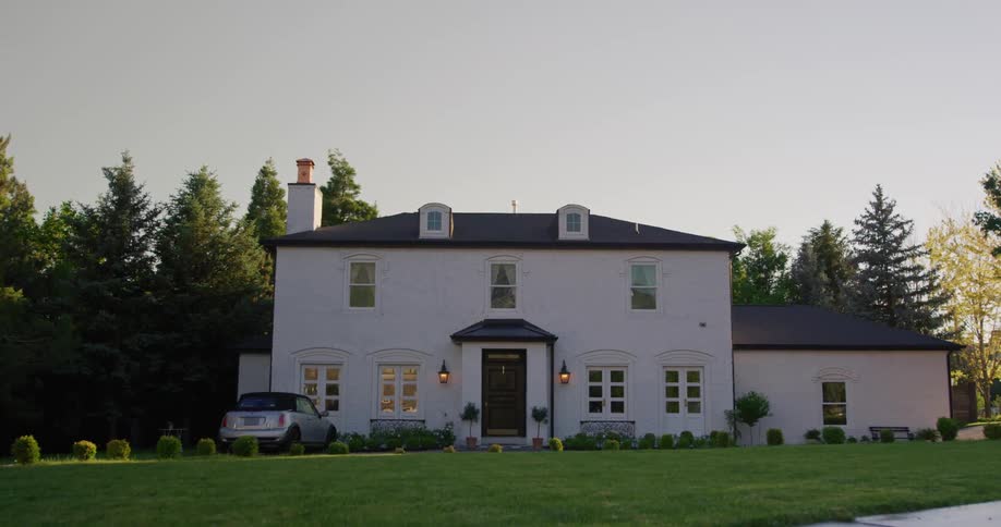 The view is of a car that is parked in front of a house in the countryside