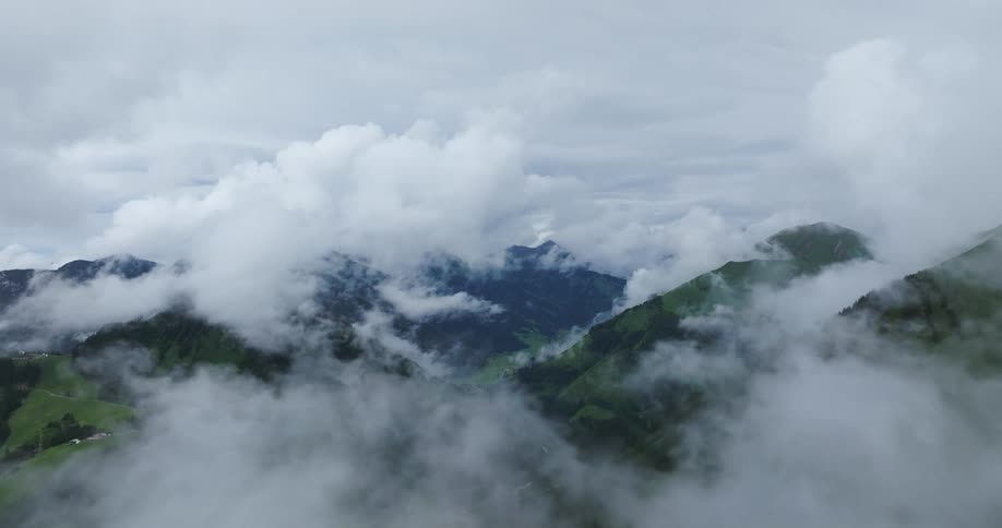 Low lying clouds obscure tops of green mountains