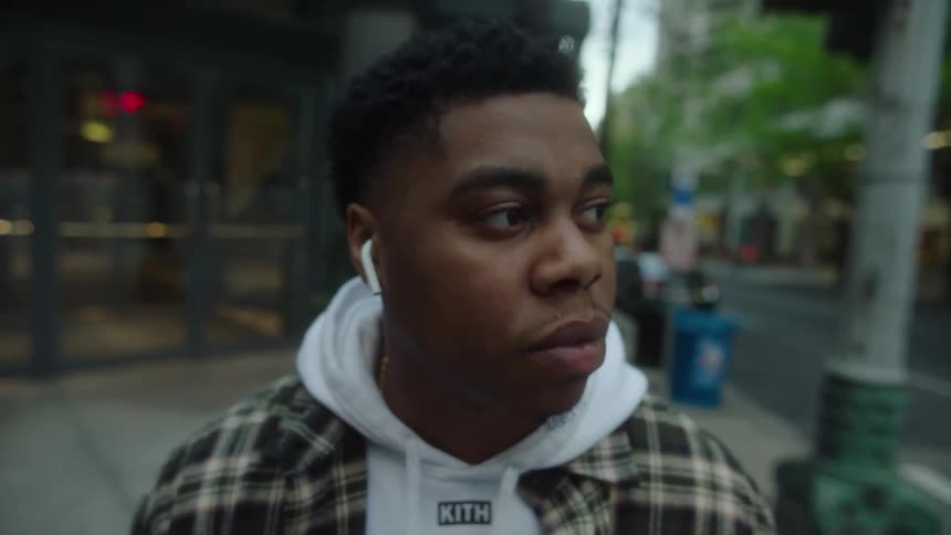 Young man standing on the corner of a street in the city looking around