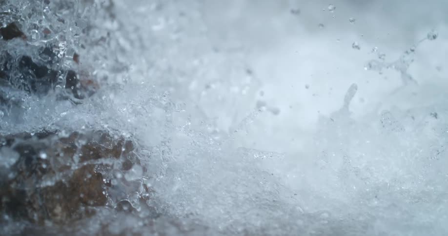 The view is of water that is splashing in the middle of the day
