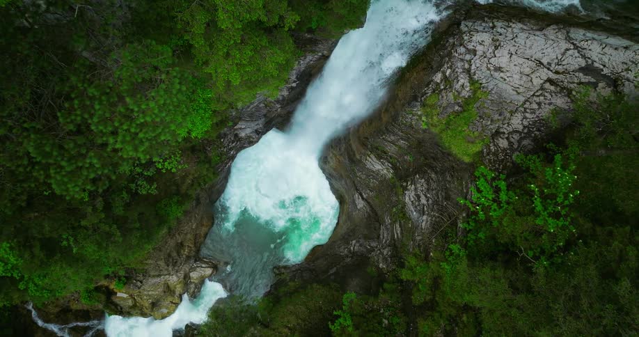 Aerial view of a waterfall in the forest is displayed