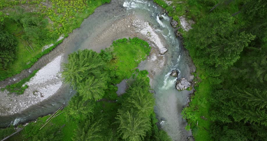 River water flows around the river bend foaming a bit as it passes rapids