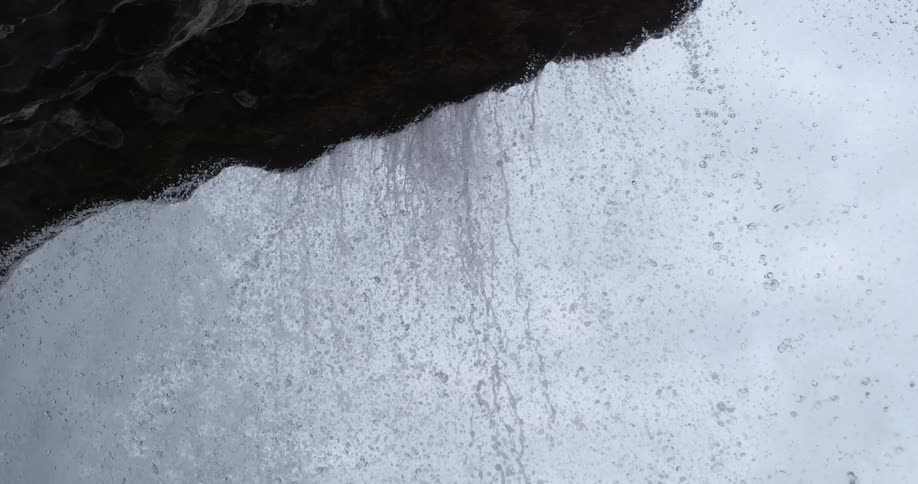 Water streaming down the edge of a cliff forming a waterfall