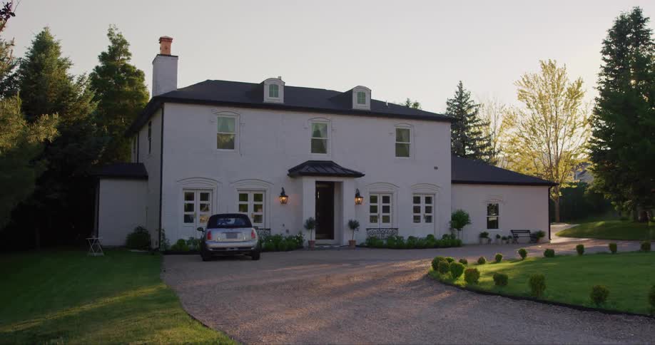 The view is of a car that is parked in front of a house in the countryside