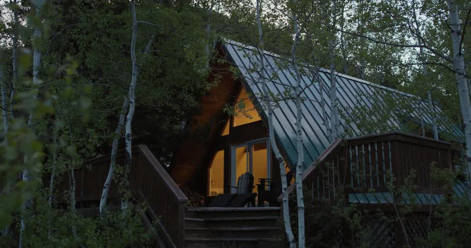 Lights of house turn on in the forest