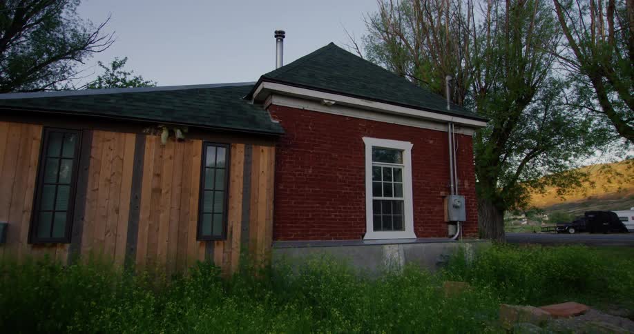 The view is of a house in the countryside located by the forest